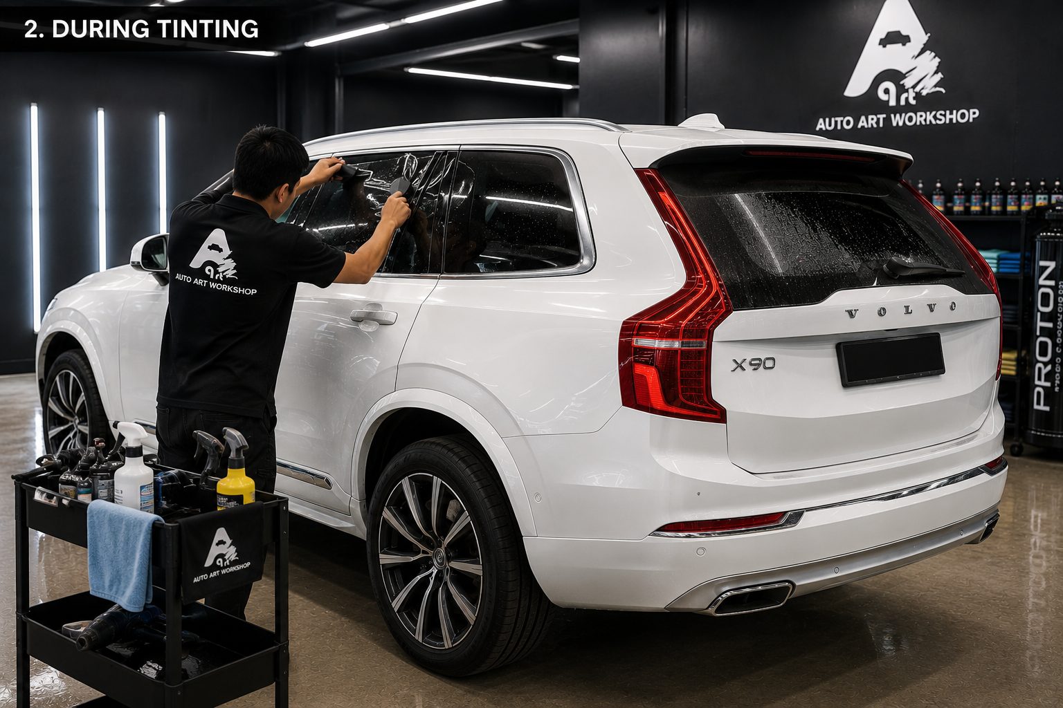 Installer applying window tint film to a Volvo XC90 rear window in Nilai